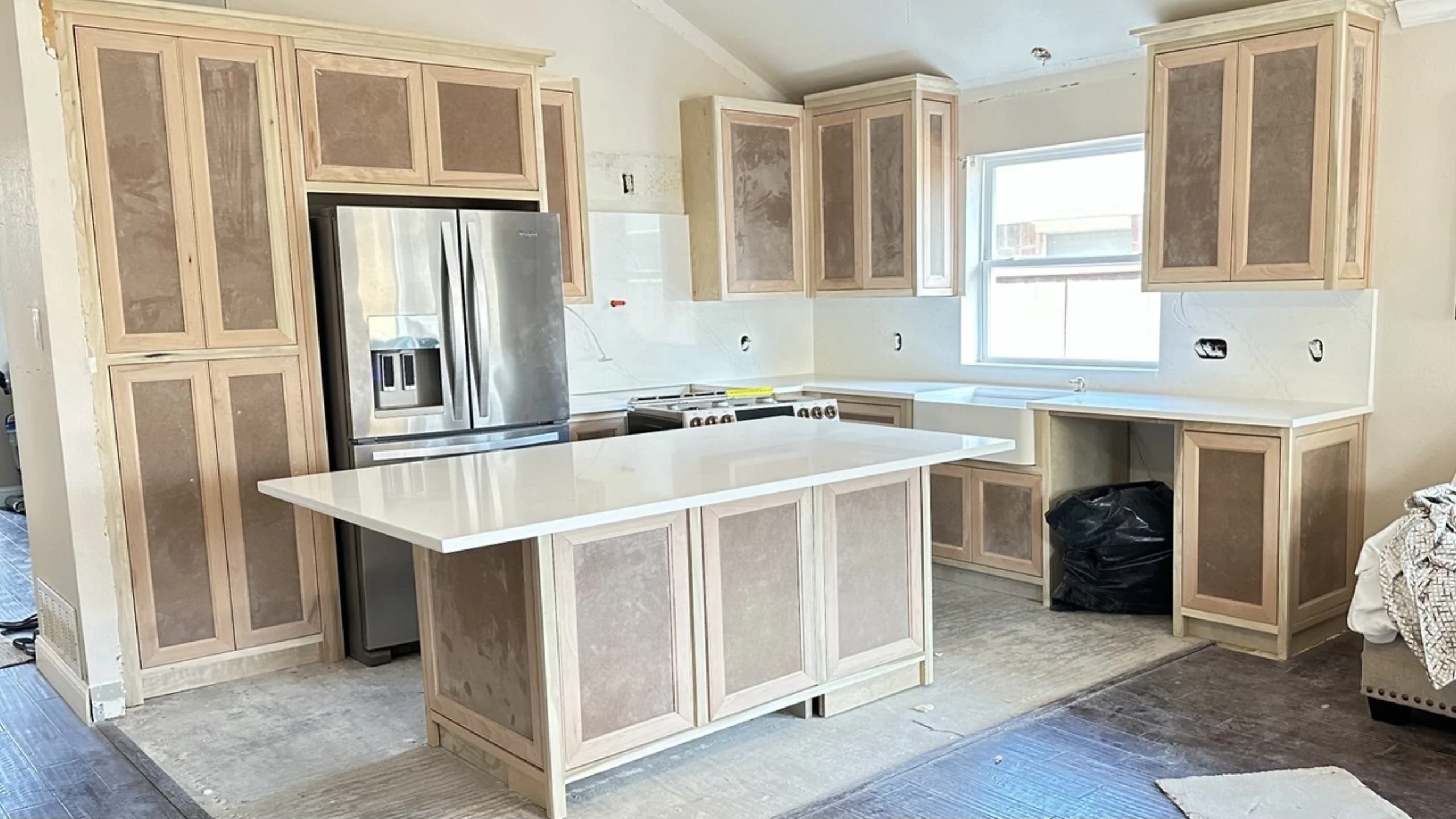 Cocina en remodelación con gabinetes de madera clara e isla central